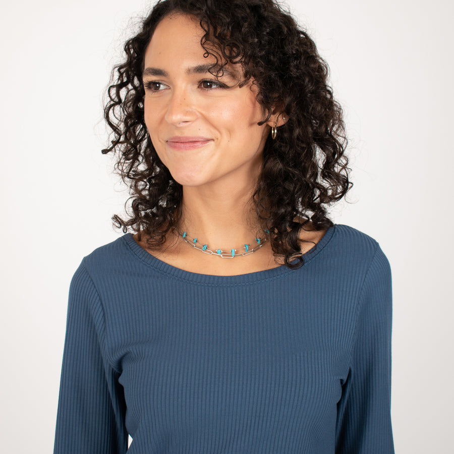Woman wearing blue rib knit reversible long sleeve top