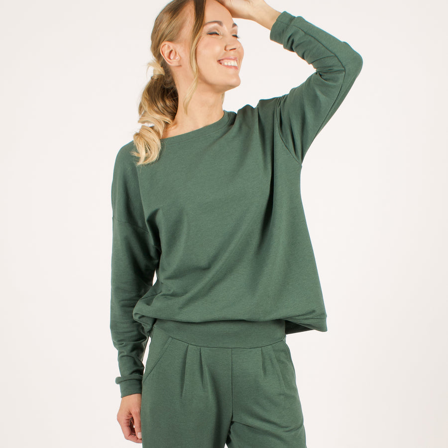 Woman wearing reversible green v-neckline loose sweatshirt with matching green sweatpants