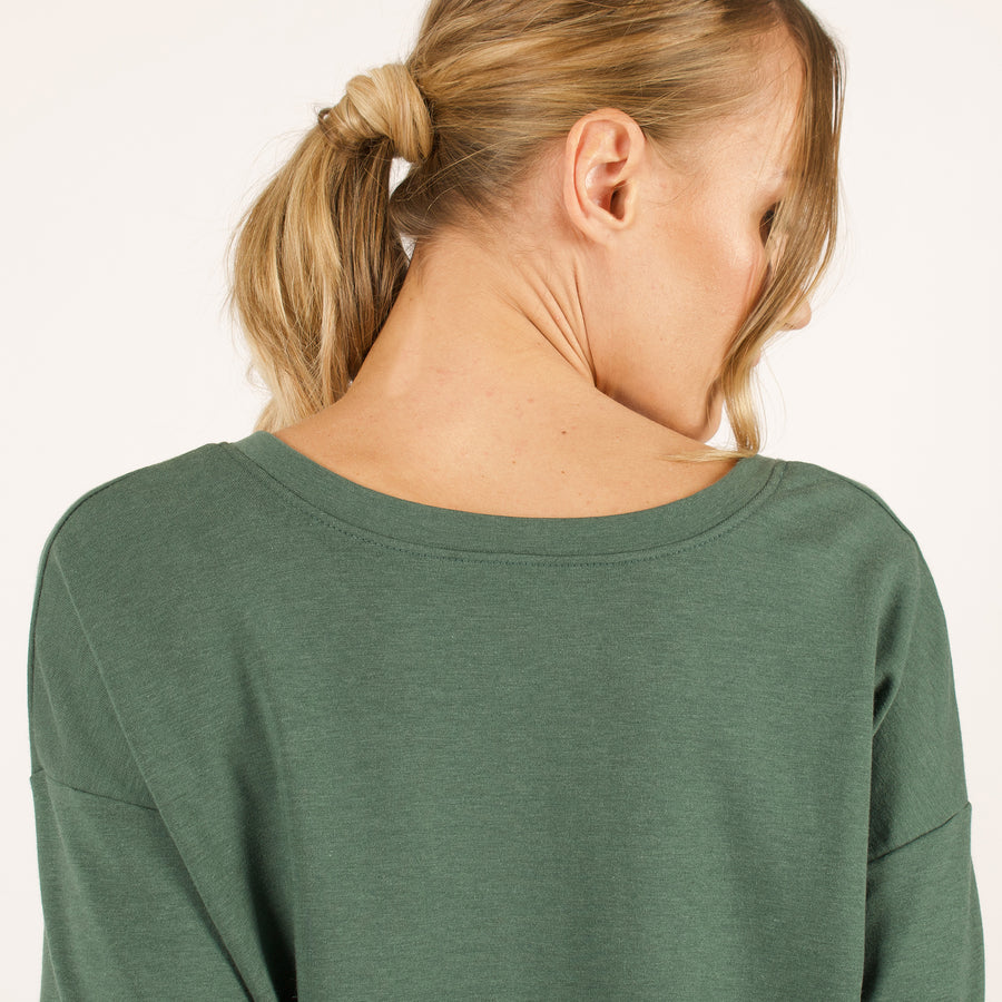 Woman wearing reversible green v-neckline loose sweatshirt