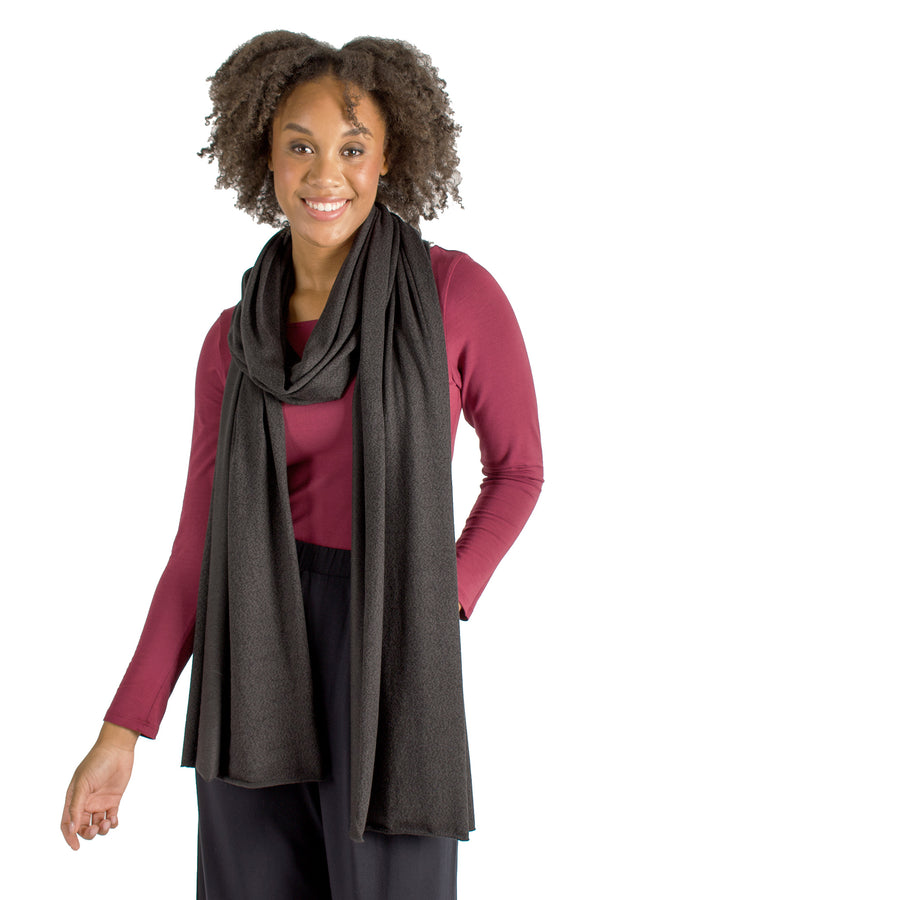 Woman wearing wrap-up scarf drapped around their upper body with maroon long sleeve shirt and black flowing pants