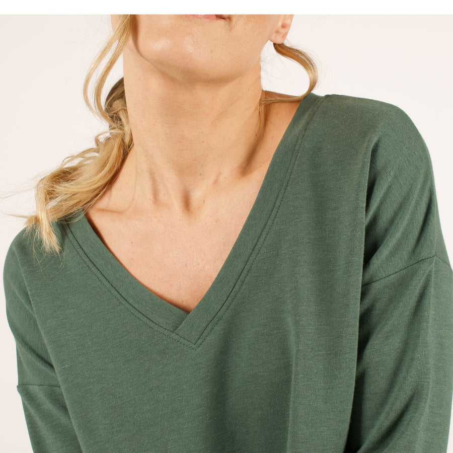 Woman wearing reversible green v-neckline loose sweatshirt