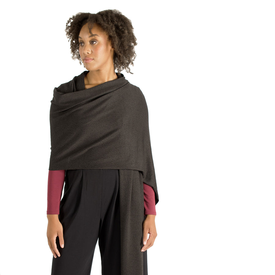 Woman wearing wrap-up scarf drapped around their upper body with maroon long sleeve shirt and black flowing pants