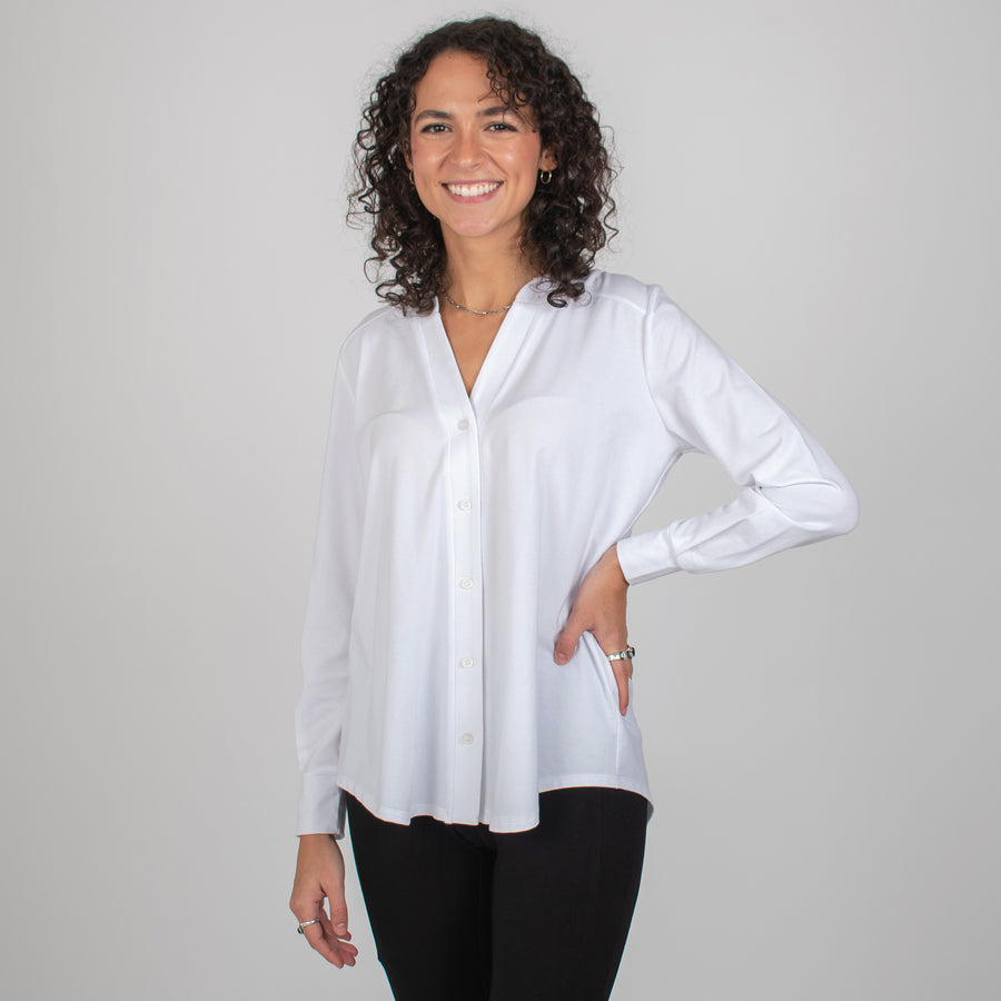 Woman wearing white long sleeve button up shirt with black tapered sweatpants