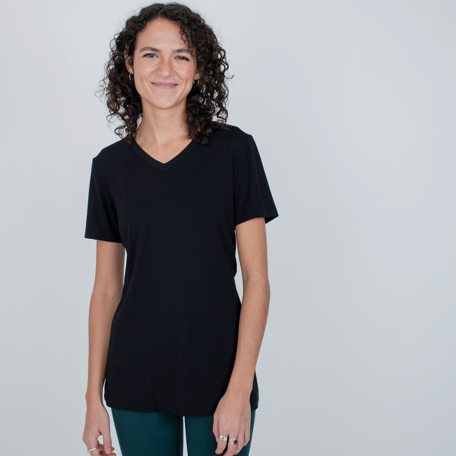 Woman wearing black v-neckline t-shirt with teal fitted leggings