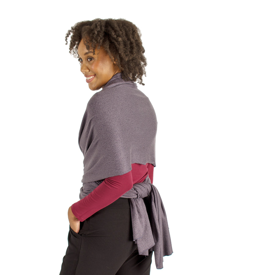 Woman wearing light grey wrap-up scarf around their upper body tied in the back with maroon long sleeve shirt and black pants