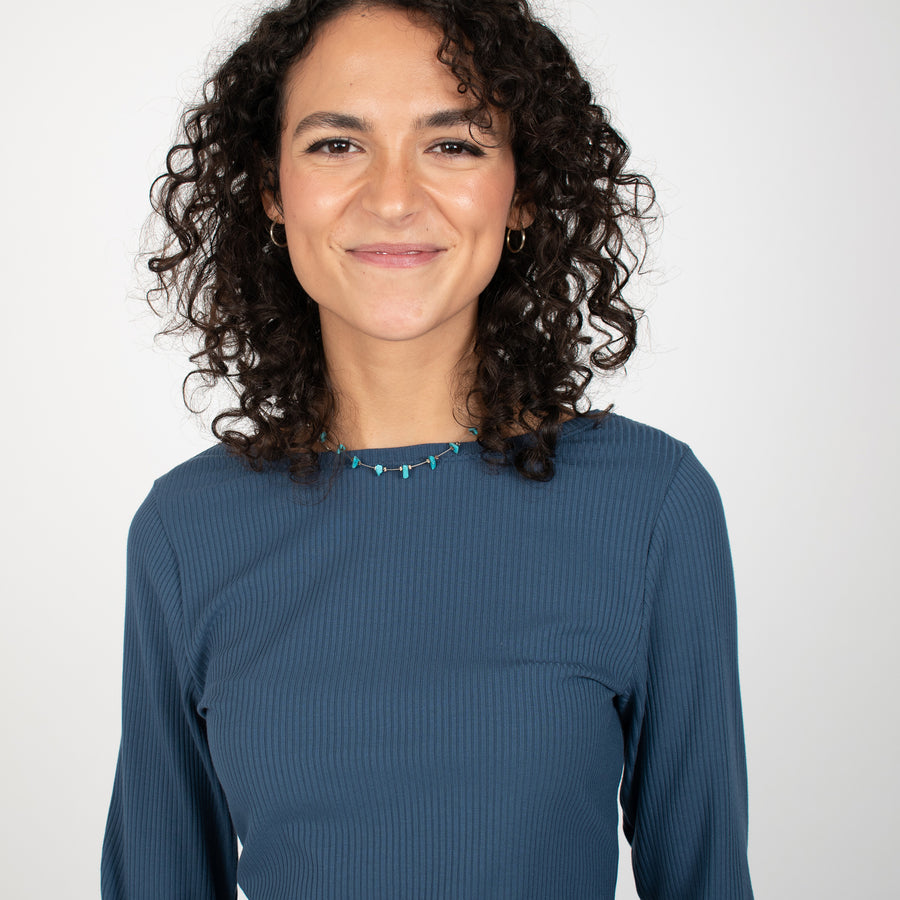 Woman wearing blue rib knit reversible long sleeve top