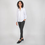 Woman wearing white long sleeve button up shirt with grey leggings