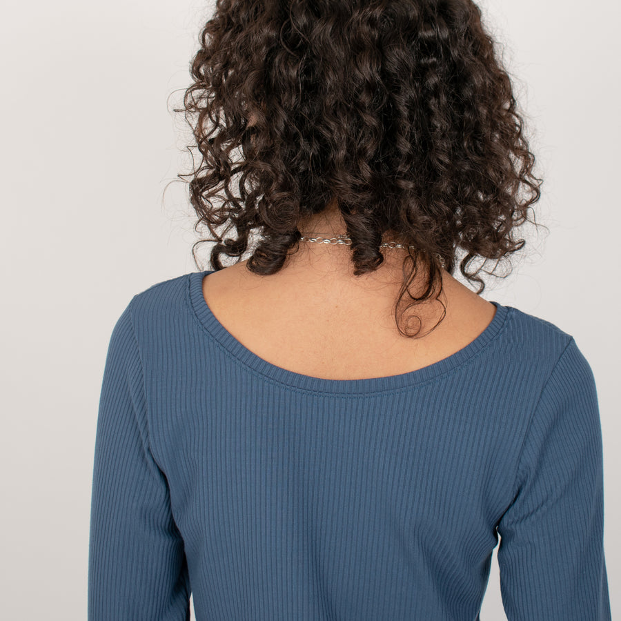 Woman wearing blue rib knit reversible long sleeve top