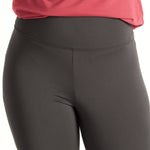 Woman wearing fitted black high-rise waist with ankle length leggings featuring seamless stitching and a hidden back pocket with red shirt