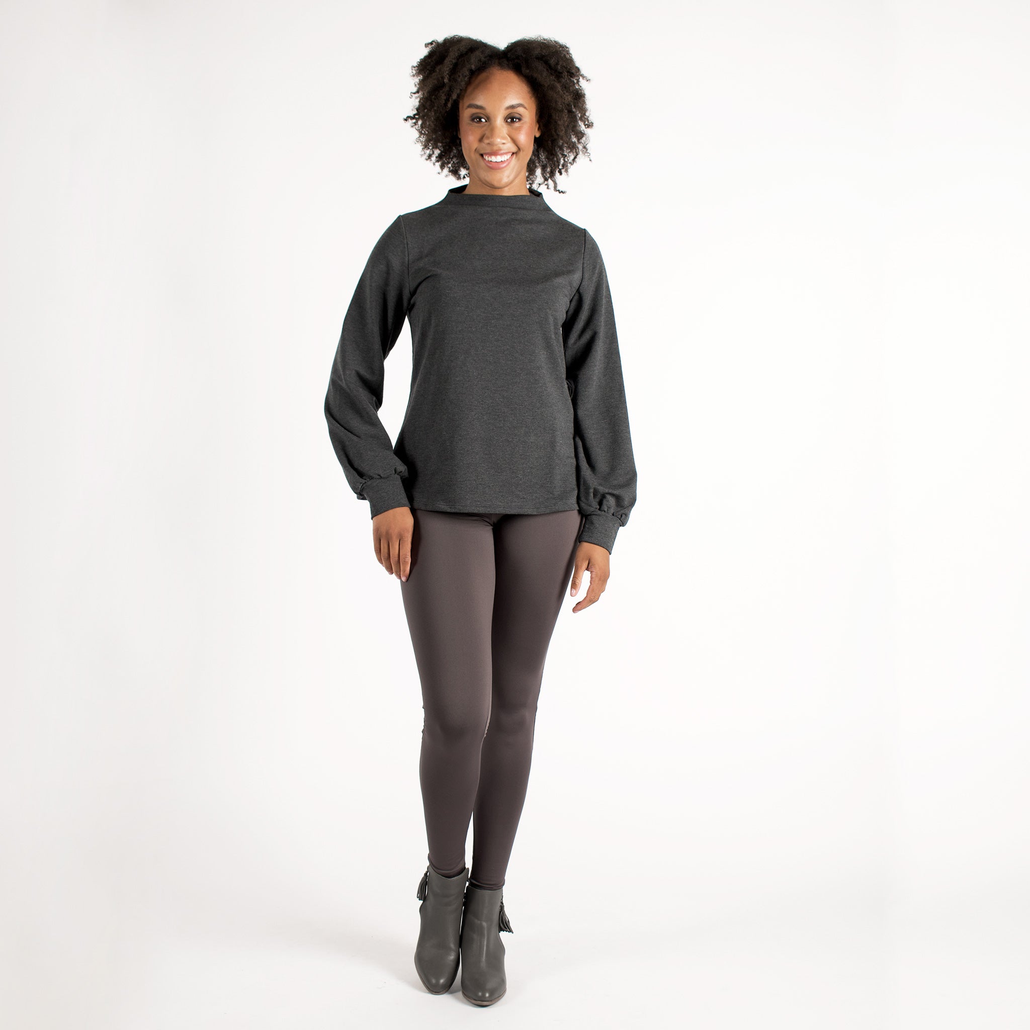 Woman wearing fitted light brown high-rise waist with ankle length leggings featuring seamless stitching and a hidden back pocket 
