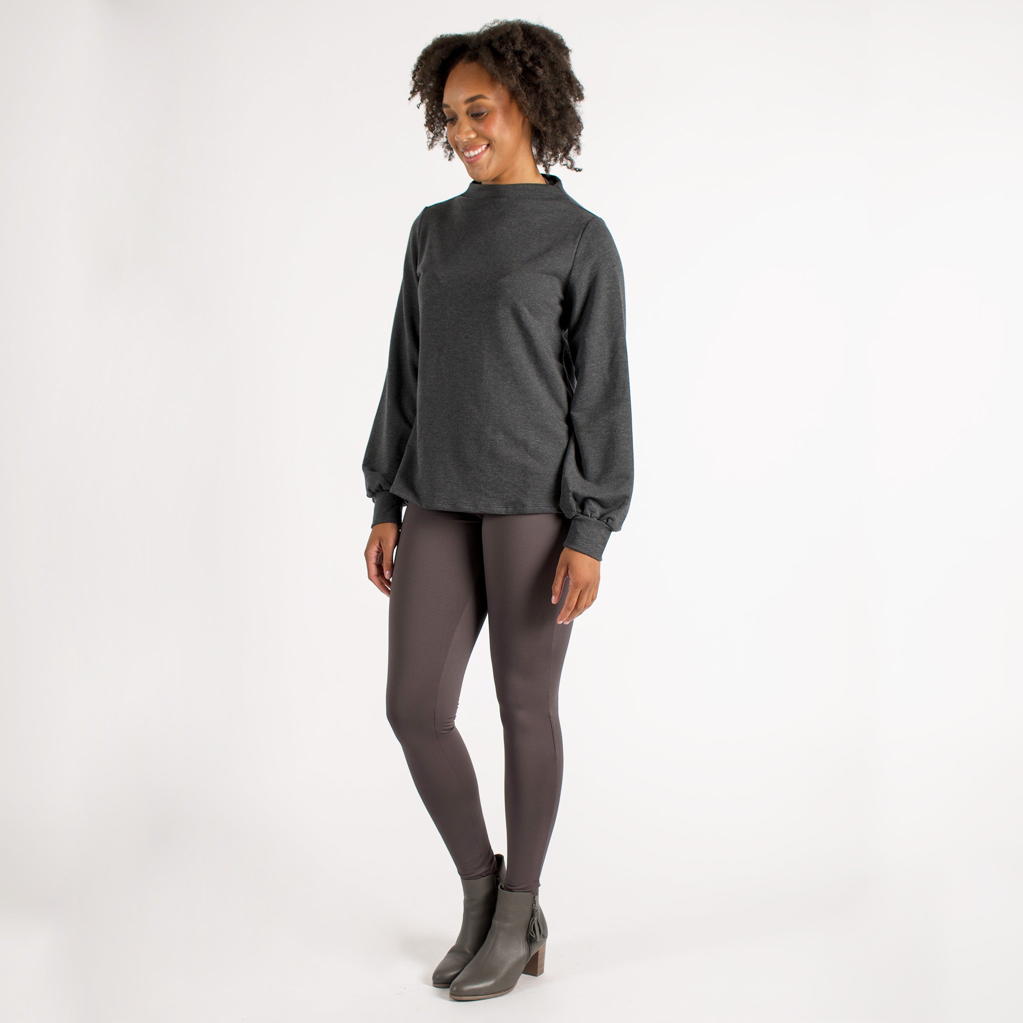Woman wearing fitted light brown high-rise waist with ankle length leggings featuring seamless stitching and a hidden back pocket 