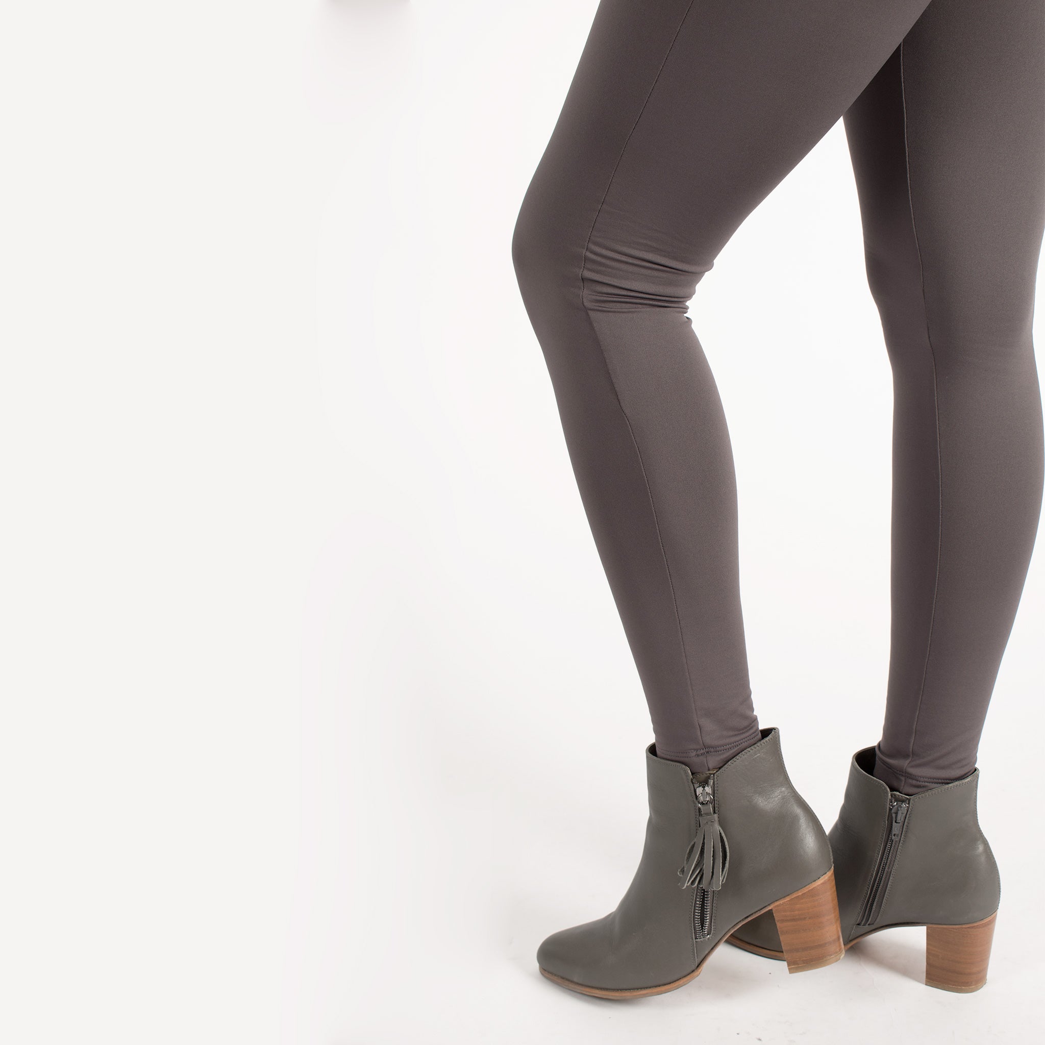 Woman wearing fitted light brown high-rise waist with ankle length leggings featuring seamless stitching and a hidden back pocket 