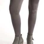 Woman wearing fitted light brown high-rise waist with ankle length leggings featuring seamless stitching and a hidden back pocket 