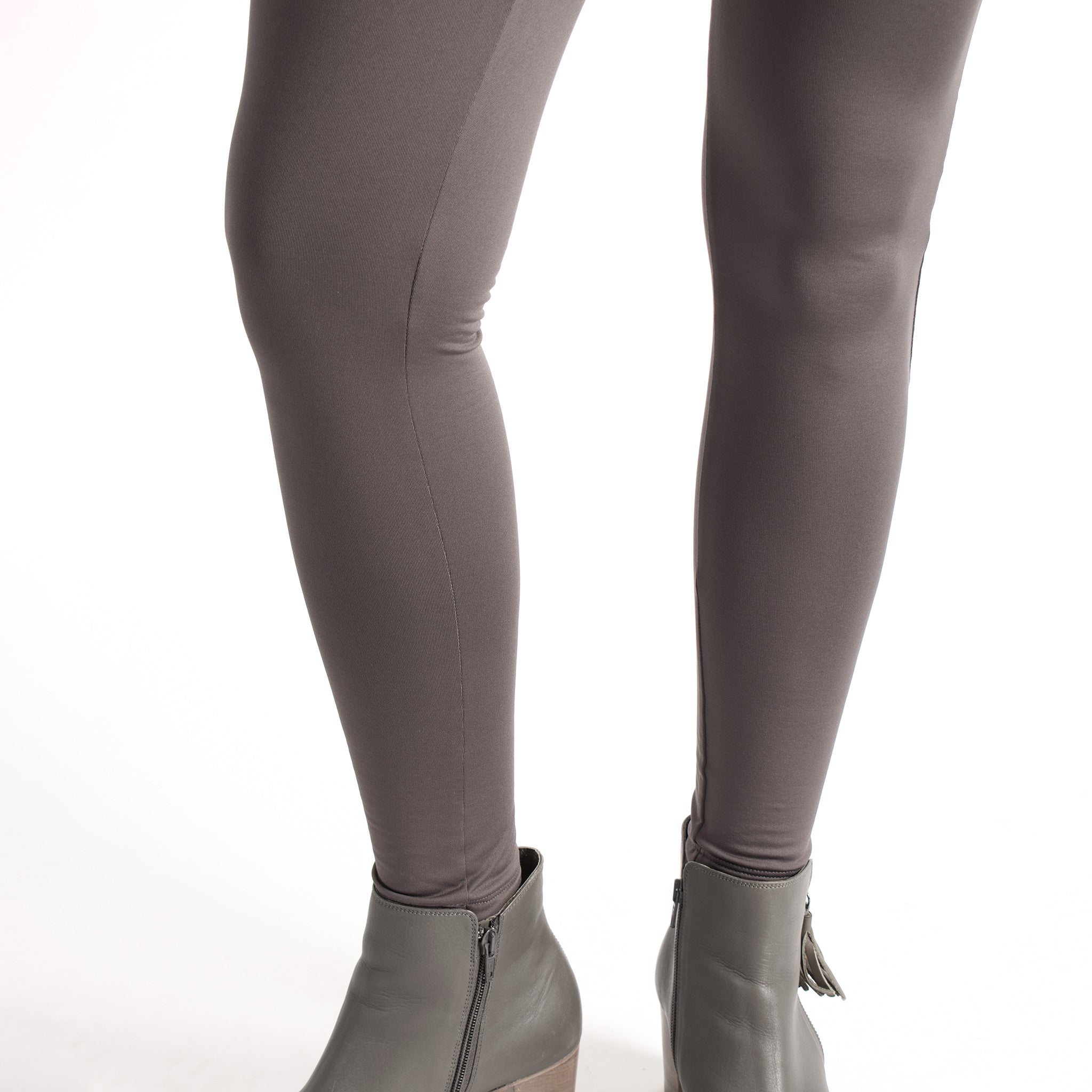 Woman wearing fitted light brown high-rise waist with ankle length leggings featuring seamless stitching and a hidden back pocket 