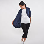 Woman wearing navy blue versatile dress as shoulder wrap with white shirt and black leggings