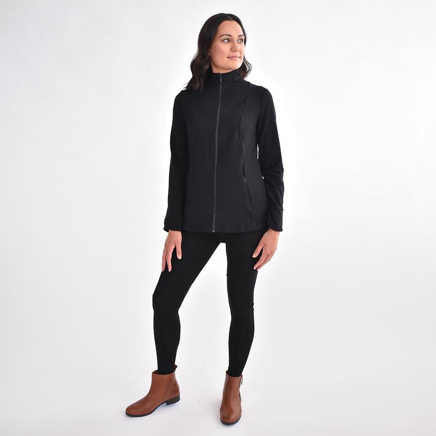 Woman wearing fitted navy stretchy front zippered jacket closed with black fitted leggings
